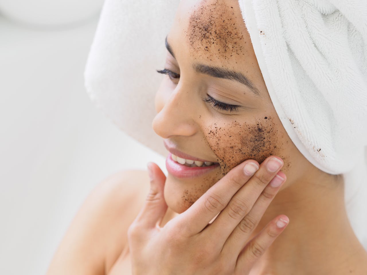 Woman enjoying skincare routine with coffee scrub exfoliation for healthy skin.
